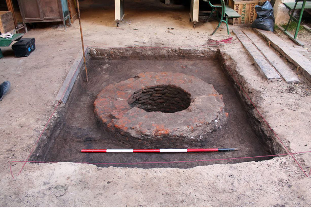 Excavación de uno de los pozos encontrados en el fondo de la casa.
